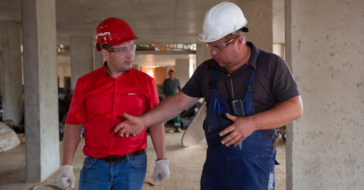 Two construction professionals discussing work at an active building site.